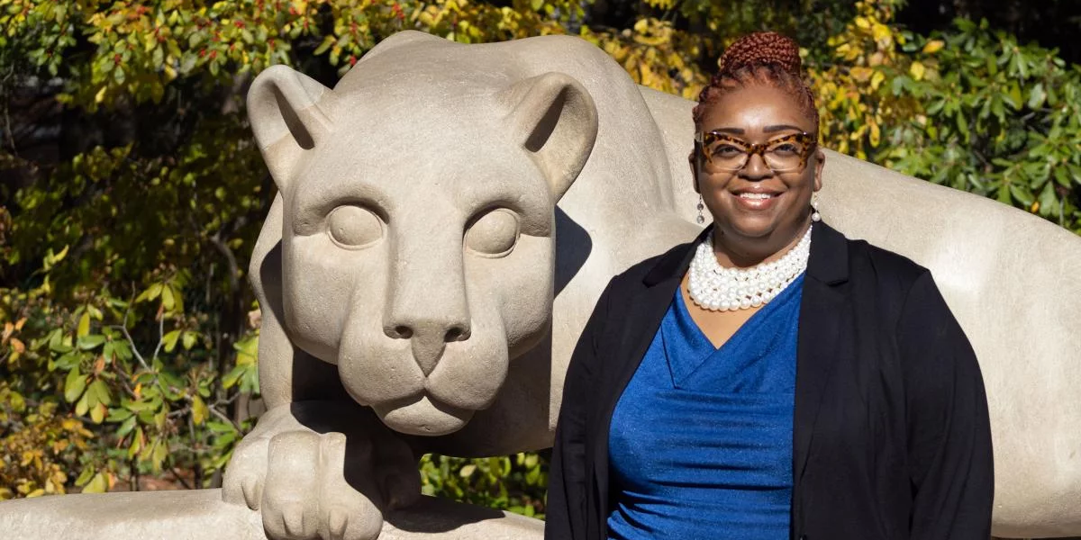 Dionne Wiggins stands next to the Nittany Lion Shrine.