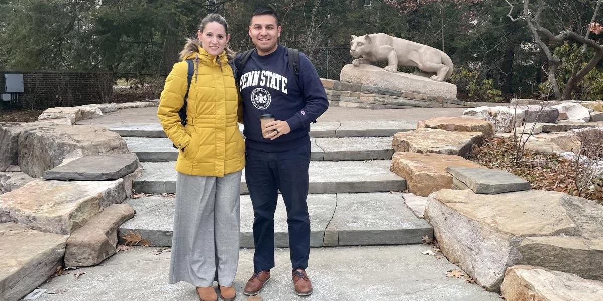 Marian Fuentes Viera and Sylvester Fernandez de Castro stand with the Nittany Lion shrine in the background.