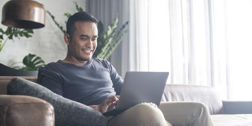 Man sitting on a couch with a laptop